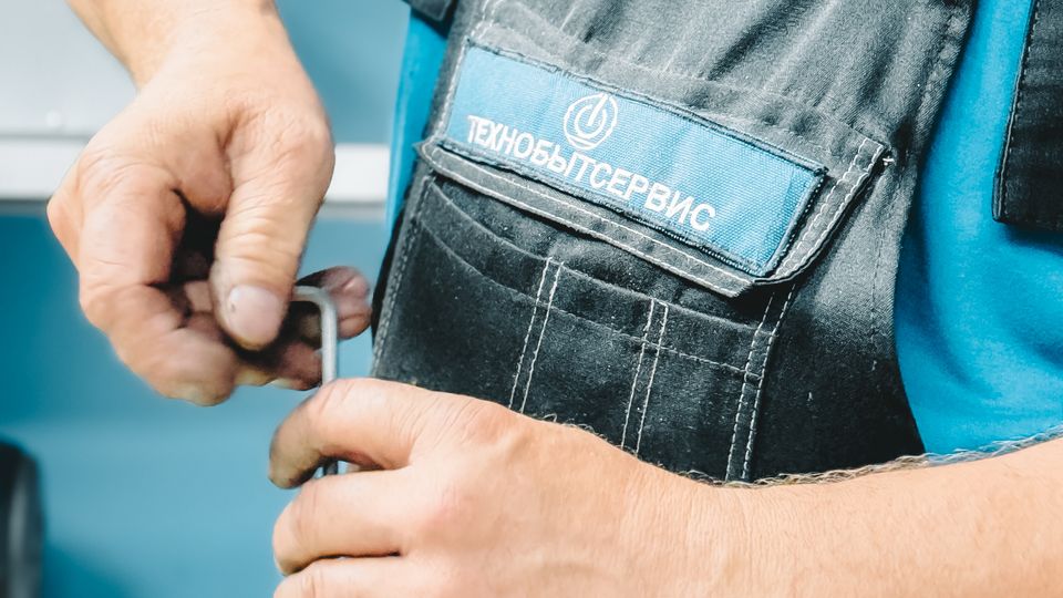Plumber repairing a pipe with a wrench under a fixture